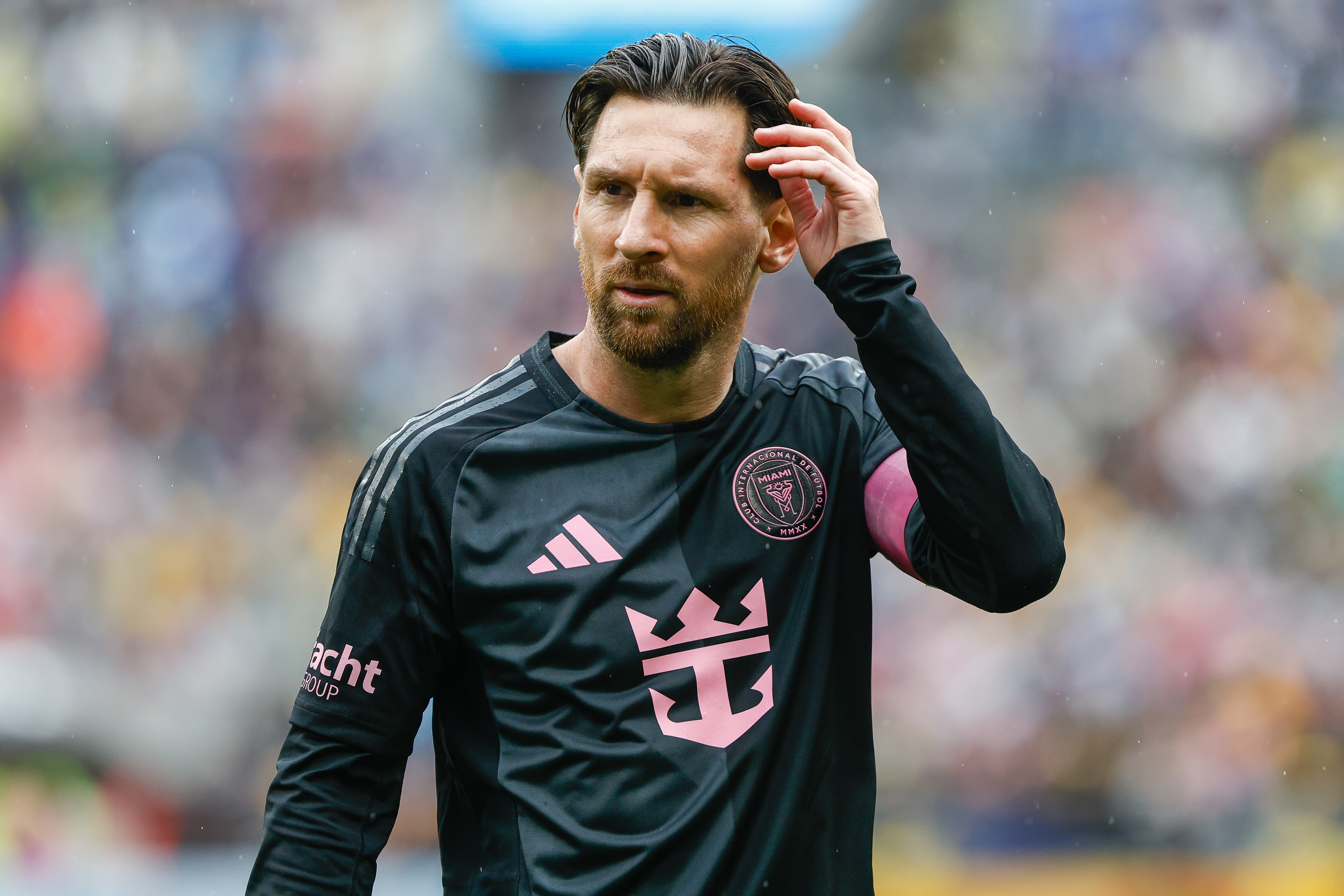 Lionel Messi walking in an Inter Milan kit, touching his hair.